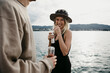 © letizia haessig photography/Westend61 - Happy young couple having a drink at a lake