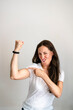 © dirk moll/Westend61 - Portrait of cheerful mature woman pointing at bicep against white background