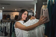 © Westend61 - Smiling beautiful woman taking selfie with outfit at store