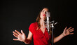© DREAMSTOCK1982/Westend61 - Portrait of female singer with microphone, wearing red dress