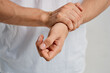 © SHOTPRIME STUDIO - a man in a white t-shirt holding a hand pain in the wrist