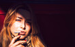 © EDUARDOHUELINPHOTO/Westend61 - Close-up of confident businesswoman smoking cigarette against wall in city