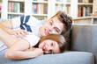 © Larissa Veronesi/Westend61 - Portrait of teenage boy and his little sister lying together on the couch at home