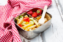 Pasta Salad, Strawberries And Crackers In Lunch Box On Wooden Table