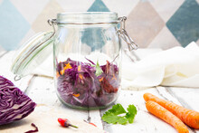 Jar Of Red Cabbage, Chili Peppers, Carrots And Coriander On Wooden Table