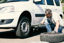 Mature Man Changing Car Tires, Top View