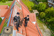 © Roman M√§rzinger/Westend61 - Portrait of two smiling chimney sweeps standing on house roof