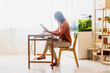 © Westend61 - Female freelancer working at home sitting at desk using tablet