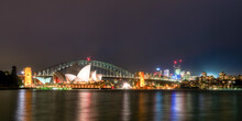 Illuminated Sydney Harbor Bridge And Buildings Over River Against Sky At Night, Australia
