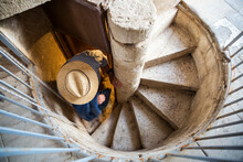 Italy, Sicily, Modica, Man With Hat On Spiral Staircase