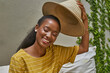 © Veam/Westend61 - Portrait of happy woman putting on a traditional hat