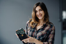Portrait Of Smiling Young Woman Showing Hard Disk
