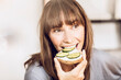© Maya Claussen/Westend61 - Mature woman eating healthy cucumber bread