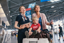 Happy Airline Employee With Mother And Child At The Airport