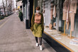 © Mareen Fischinger/Westend61 - Woman wearing mask walking along clothing store in the city