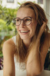 © Mareen Fischinger, Photographer/Westend61 - Portrait of happy young woman with glasses looking sideways