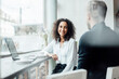 © Joseffson/Westend61 - Smiling businesswoman talking with colleague while sitting by laptop at cafe