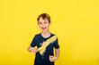 © JOSEP M ROVIROSA/Westend61 - Portrait of cheerful boy playing with paintbrush while standing against yellow background