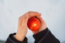 Close-up Of Young Woman Hands Holding Candle Over Snow Covered Land