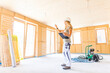 © Thomas Degen/Westend61 - Young woman checking the construction of a new wooden house