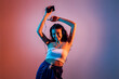 © Julio Rodriguez/Westend61 - Teenage girl holding smart phone dancing while enjoying music against colored background