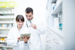 © Pavel Horak/Westend61 - Two pharmacists using tablet in pharmacy