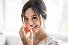 Laughing Woman Smelling An Apricot