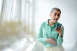 © KNSY/Westend61 - Woman in a loft using smartphone sticking out her tongue