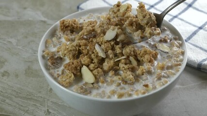 Wall Mural - Eating a spoonful of organic almond granola with milk slow motion
