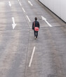 © UWE_UMSTAETTER/Westend61 - Rear view of businessman walking on road with arrow signs