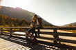 © UWE_UMSTAETTER/Westend61 - Austria, Alps, couple on a hiking trip having a break on a bridge
