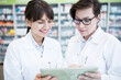 © Pavel Horak/Westend61 - Two pharmacists using tablet in pharmacy