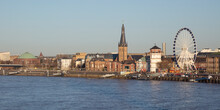 Germany, North Rhine-Westphalia, Dusseldorf, City Waterfront With Ferris Wheel And Saint Lambertus Church In Background