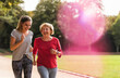 © UWE_UMSTAETTER/Westend61 - Granddaughter and grandmother having fun, jogging together in the park