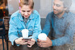 © William Perugini/Westend61 - Young woman using smartphone in a coffee shop while her boyfriend watching her