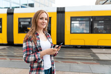 Portrait Of A Smiling Woman In The City With A Tram In The Background, Berlin, Germany