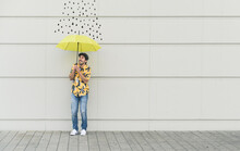 Digital Composite Of Young Man Holding An Umbrella At A Wall With Raindrops