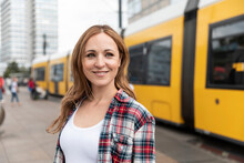 Smiling Woman In The City With A Tram In The Background, Berlin, Germany