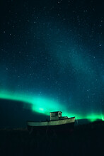 Norway, Lofoten Islands, Eggum, Fishing Boat Under Starry Sky And Nothern Lights