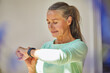 © Maya Claussen/Westend61 - Confident woman checking the time against wall at home