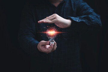 Poster - One hand of Businessman holding glowing Lightbulb and other hand protecting it for prevent creative thinking idea and patent concept.
