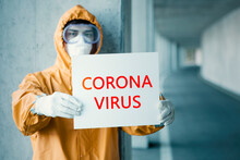 Portrait Of Man Wearing Protective Clothing Holding 'Corona Virus' Sign
