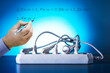 © Sergey - Electrical wires plugged into power bar and male hand writing the text. Energy audit concept.
