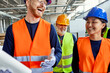 © Dangubic/Westend61 - Happy colleagues in protective workwear talking in factory