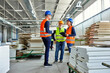© Dangubic/Westend61 - Colleagues in protective workwear talking in factory