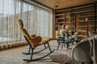 © Mareen Fischinger/Westend61 - Man with smart phone sitting on chair while looking through window in living room