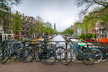 Netherlands, Amsterdam, Bicycles Parked Along Railing Of Canal Bridge