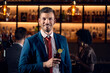© Dangubic/Westend61 - Portrait of a happy young man having a cocktail in a bar
