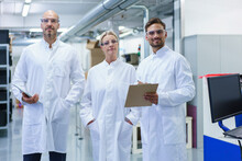 Confident Male And Female Scientists Standing In White Lab Coat At Illuminated Laboratory