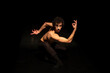 © Nadine Ginzel/Westend61 - Male ballet dancer performing on black stage